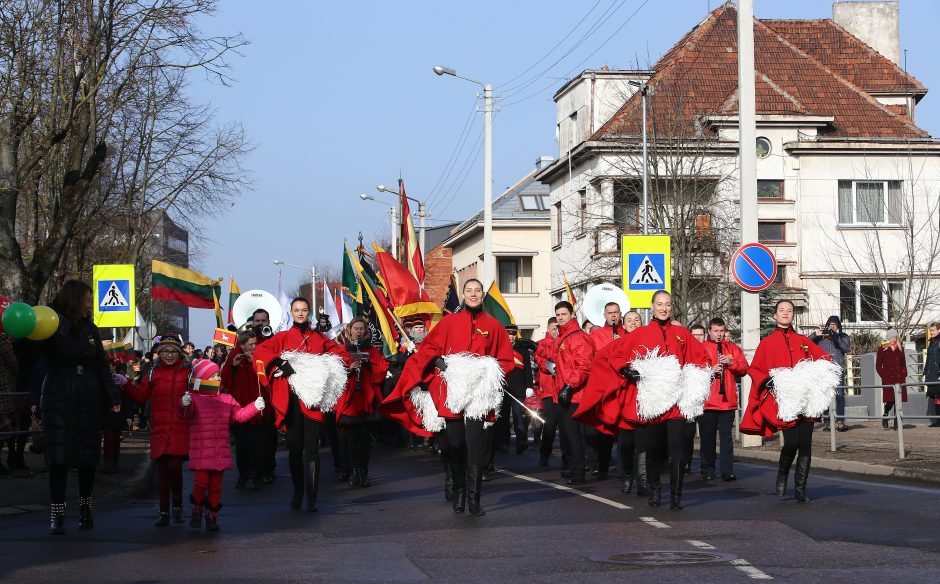 Miestą judino nuotaikinga eisena su orkestru priešakyje