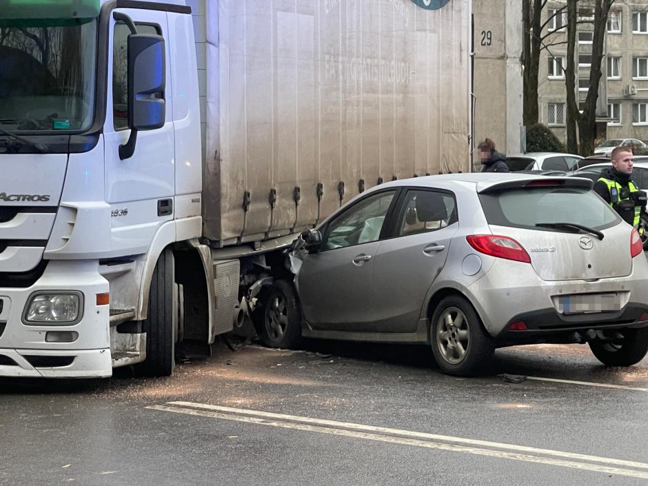 Nekasdienė avarija: lengvasis automobilis palindo po kroviniu