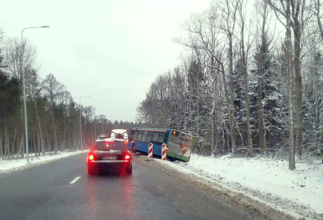 Pagalba: ant slidaus kelio neišsilaikiusį autobusą kranas iš griovio ištraukė tik pirmadienį.
