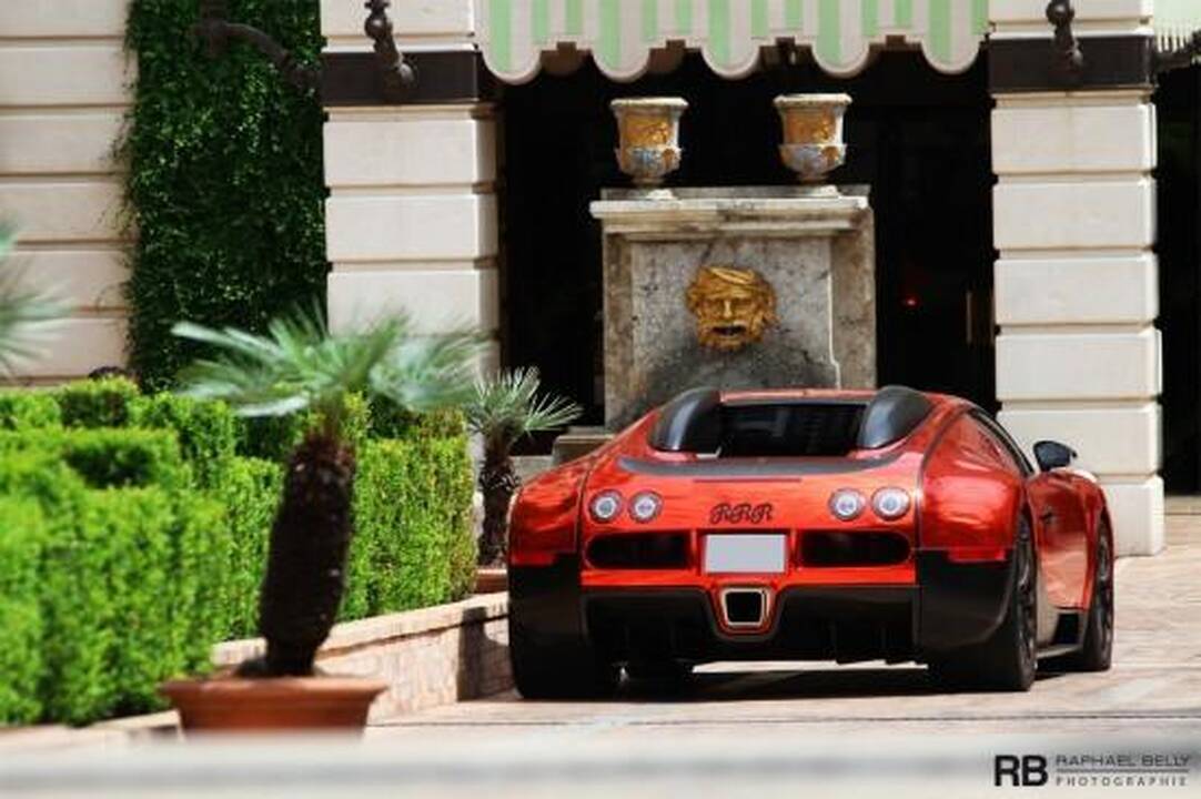 Akinančiai blizgantis raudonas „Bugatti Veyron“