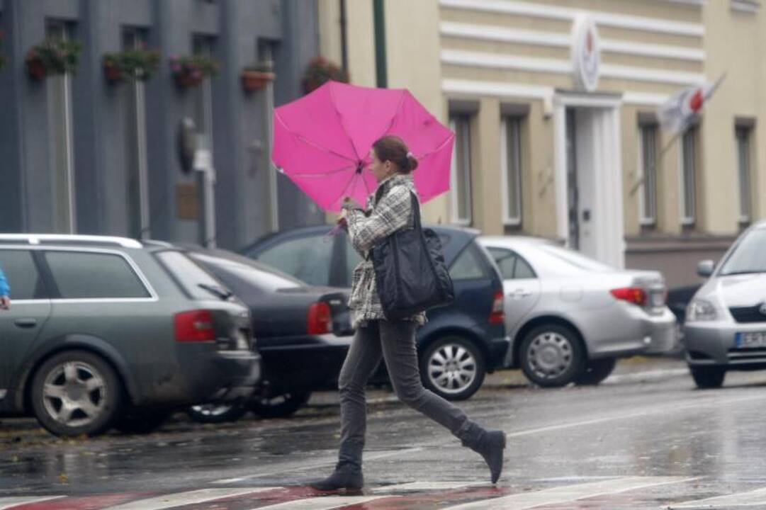 Orai pajūryje vers ginkluotis skėčiais   