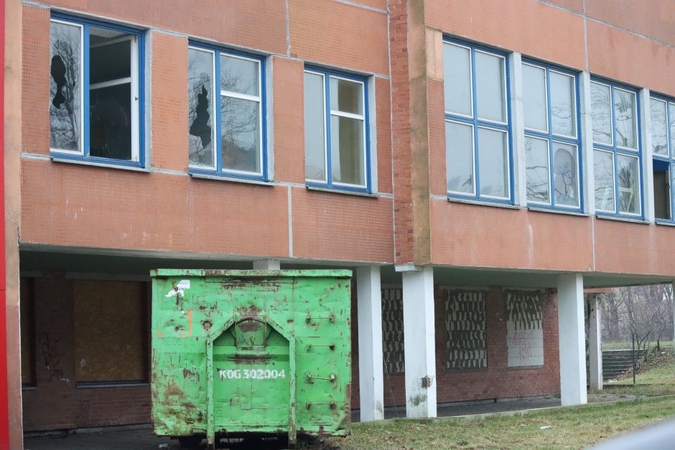 Veiksmas: patalpas kuopiantys darbininkai į šiukšlių konteinerius jau krauna atliekas, tarp jų – ir stiklo šukes, kurių čia apstu.