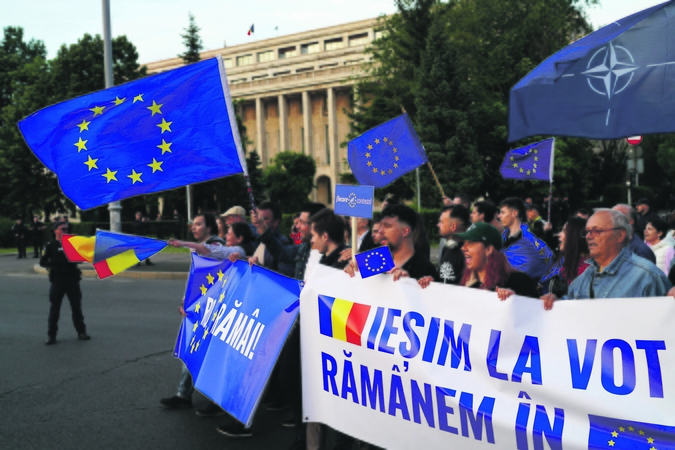 Pasirinkimas: lemiamoje dvikovoje susitinka ne tik du kandidatai į prezidentus, bet ir dvi pasaulėžiūros. Nuotraukoje – Bukarešte surengtos Europos dienos eisenos dalyviai su plakatais, kuriuose kalbama apie ryžtą balsuoti ir likti ES.