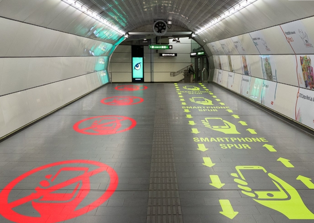 Metropoliteno stoties koridorius, padalytas į juostas „su išmaniaisiais telefonais“ ir „be išmaniųjų telefonų“.