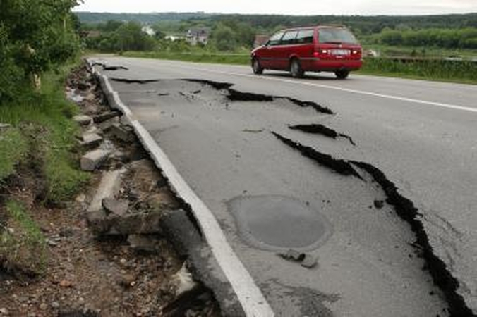Lietus išardė asfaltą nuovažoje nuo tilto per Nerį